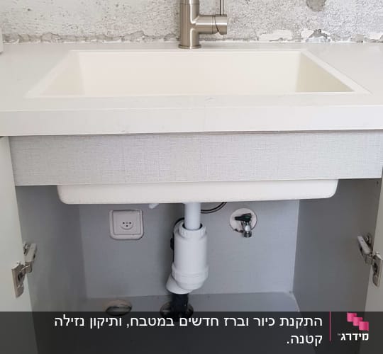 כיור עם ברז, צנרת מתחת לארון פתוח